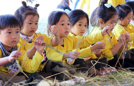 19일 청명한 가을 날씨 속에 경기도 이천시 설봉공원에서 열린 '2018이천쌀문화축제'를 찾은 어린이들이 볏짚으로 새끼꼬기 체험을 하고 있다. 올해로 성년을 맞은 올해 축제는 이천쌀과 가마솥을 주제로 한 '가마솥밥 이천명 이천원', '이천쌀밥 명인전', '가마솥체험' 등 어느 해보다 풍성한 볼거리와 먹거리, 즐길 거리가 있다.